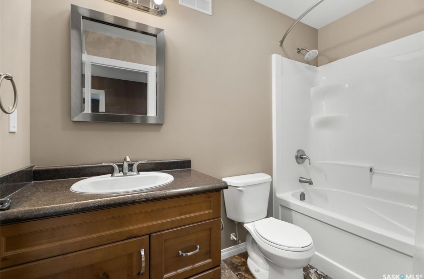 Full bathroom with toilet, tile floors, bathtub / shower combination, and vanity