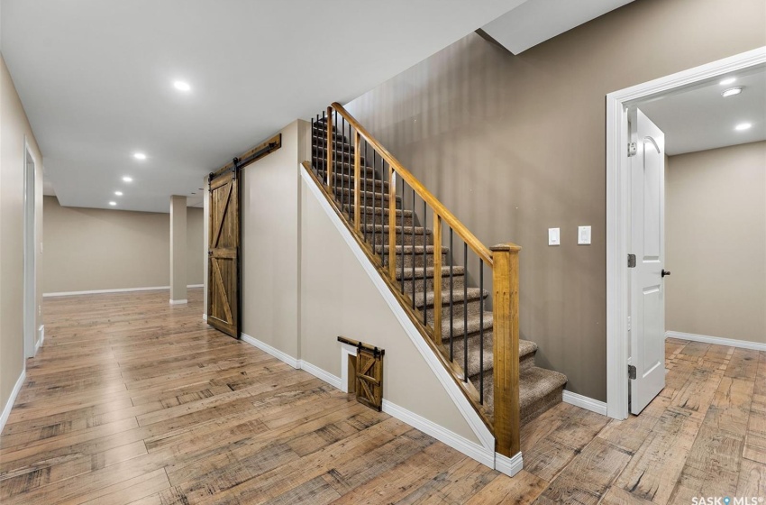 Stairway featuring light hardwood / wood-style flooring and a barn door