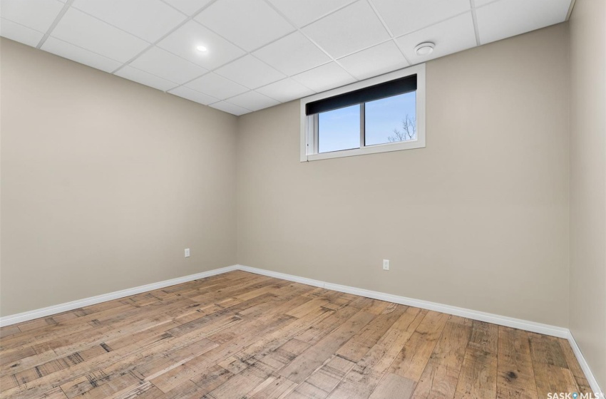 Unfurnished room with light wood-type flooring and a drop ceiling