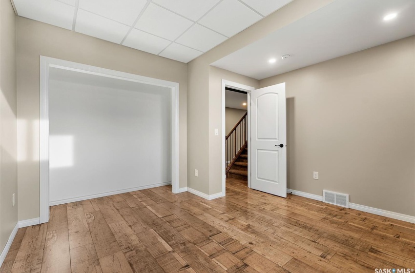 Empty room featuring light hardwood / wood-style flooring and a drop ceiling