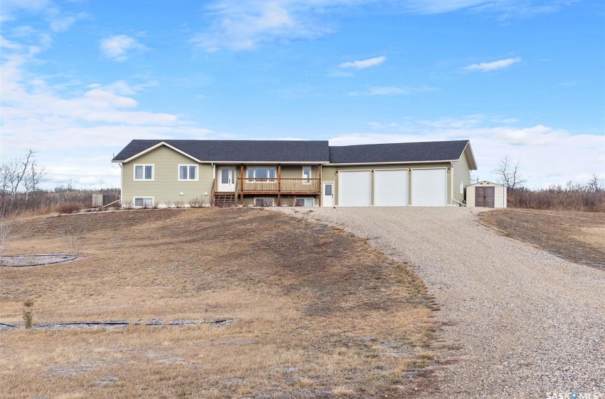 Single story home featuring a shed, a garage, and a wooden deck