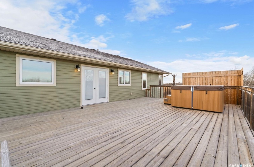 Wooden terrace featuring french doors and a hot tub