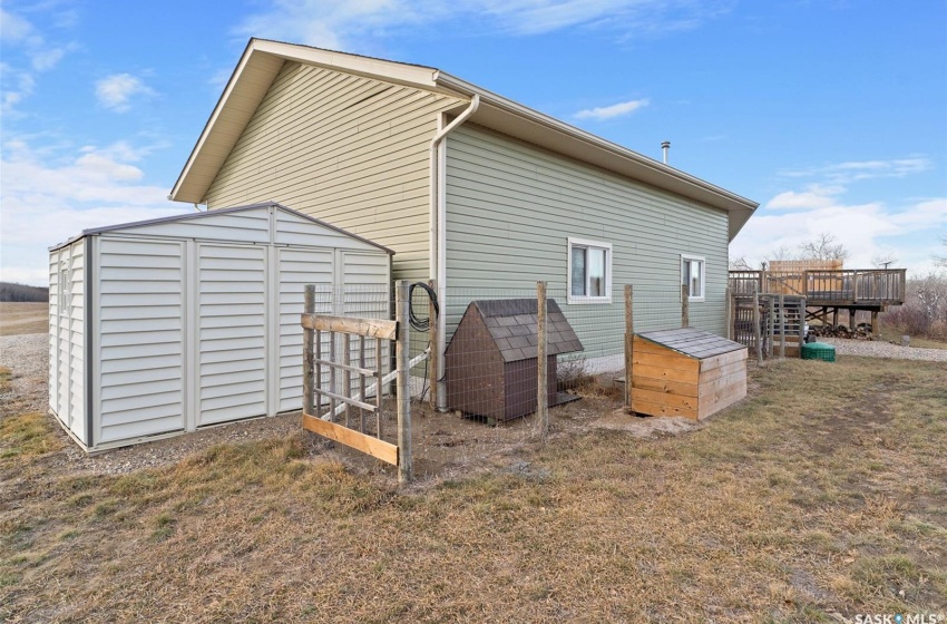 Rear view of property with a shed and a deck