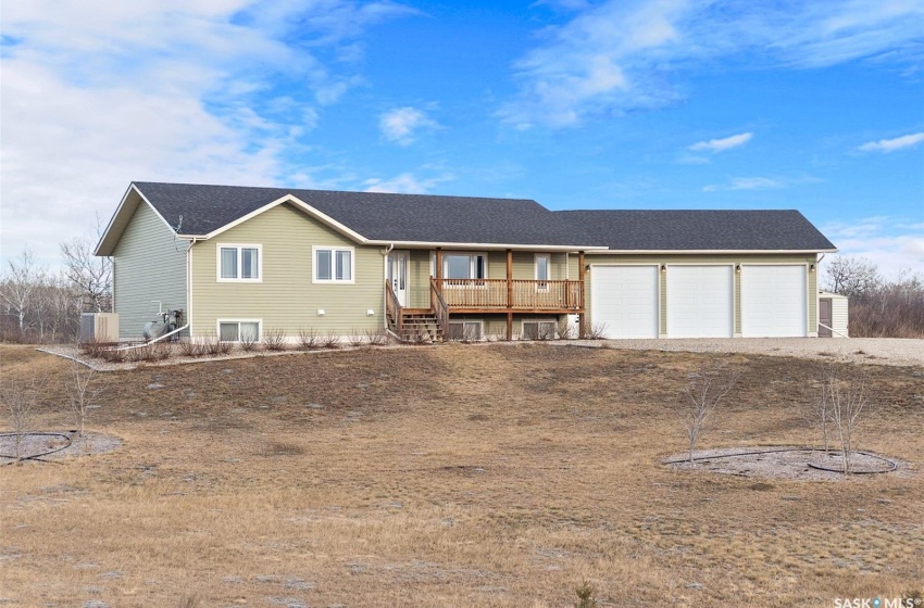 View of front facade with a garage and a wooden deck