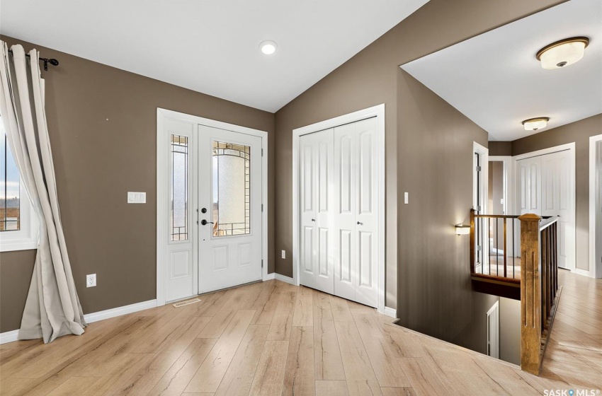 Entryway featuring light wood-type flooring and vaulted ceiling