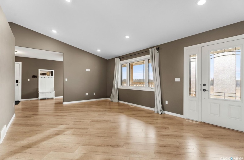 Entrance foyer with light hardwood / wood-style flooring and vaulted ceiling