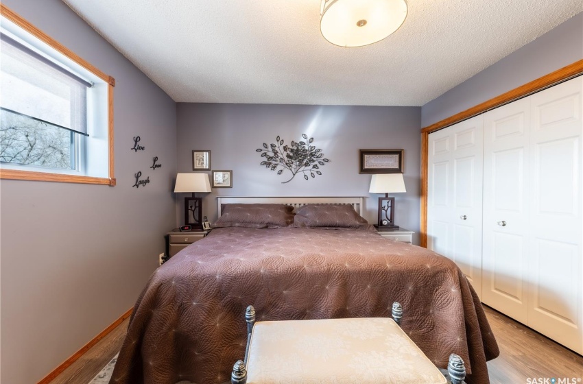 Bedroom featuring a textured ceiling, light hardwood / wood-style flooring, and a closet