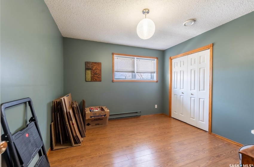 Misc room with light wood-type flooring, a textured ceiling, and a baseboard radiator