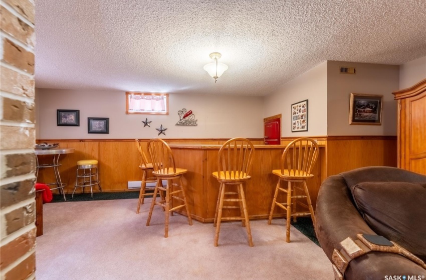 Bar with carpet floors and a textured ceiling