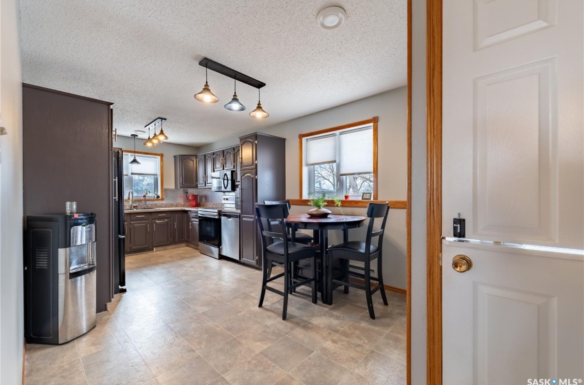 Dining room with light tile floors, a textured ceiling, rail lighting, and a healthy amount of sunlight