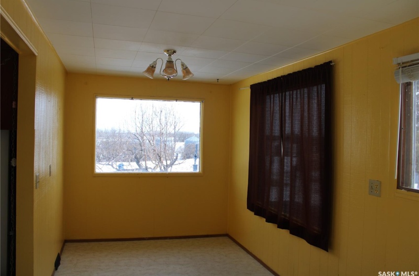 Unfurnished room featuring a chandelier and light carpet