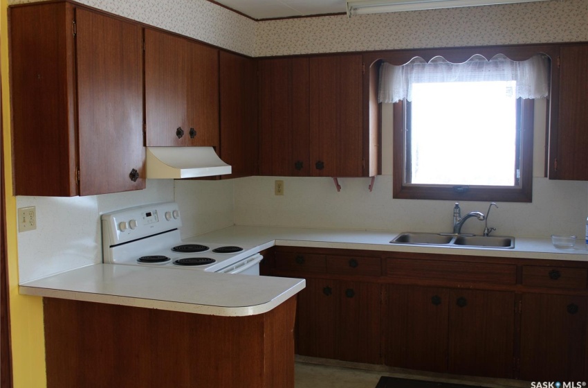 Kitchen featuring sink, white range with electric cooktop, and custom exhaust hood