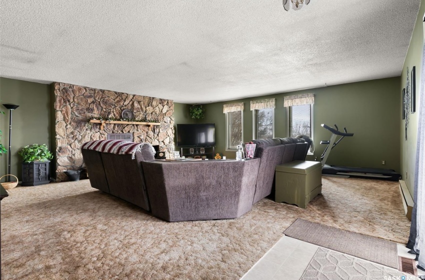 Tiled living room featuring a textured ceiling and a baseboard radiator