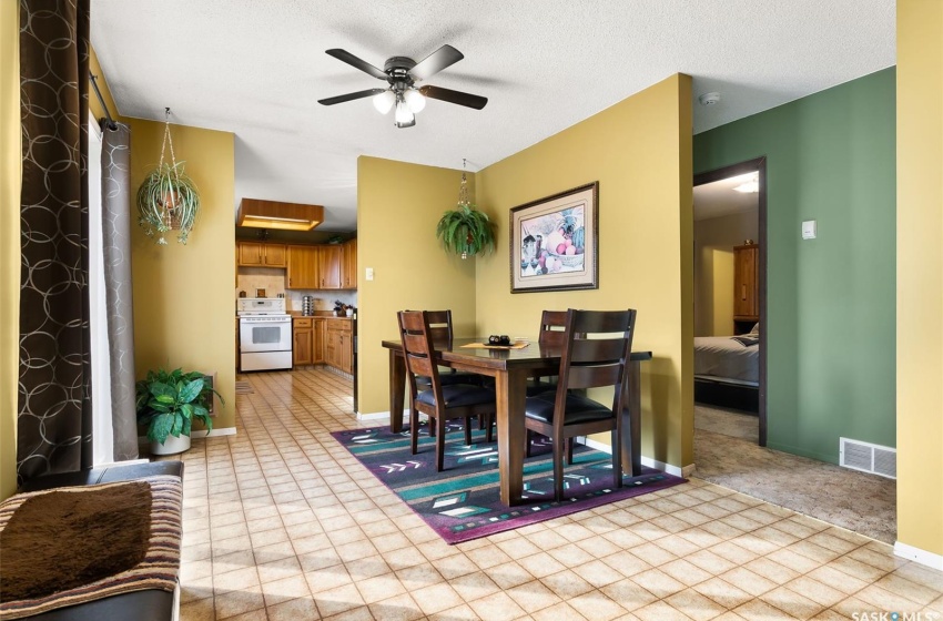 Tiled dining area featuring ceiling fan and a textured ceiling