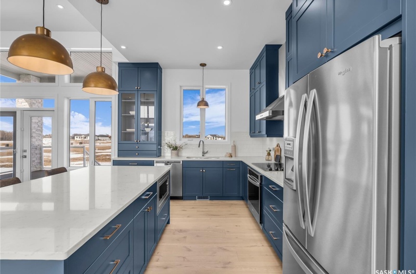 Kitchen featuring a center island, tasteful backsplash, exhaust hood and appliances with stainless steel finishes.