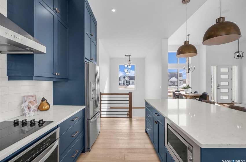 Kitchen featuring a center island, tasteful backsplash, exhaust hood and appliances with stainless steel finishes.