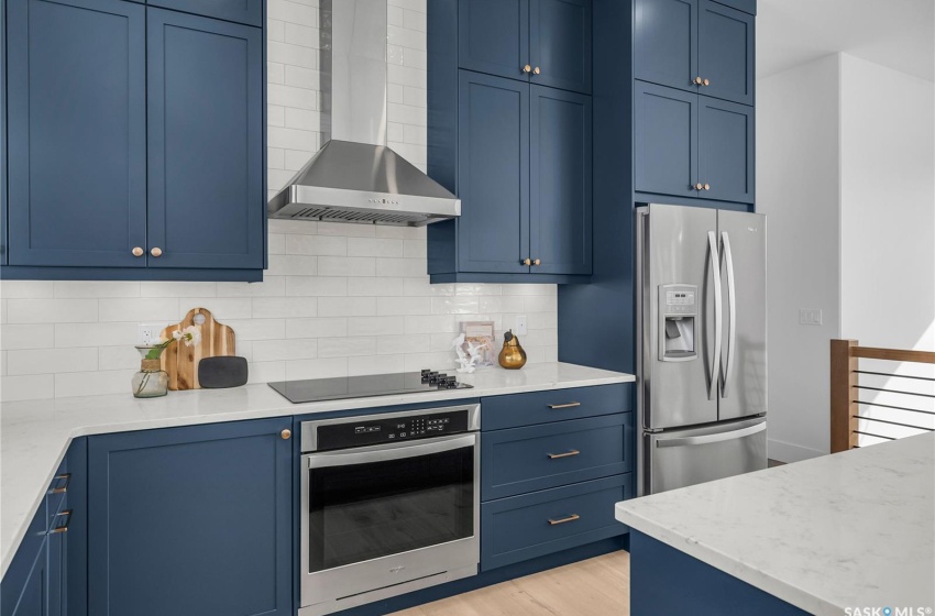 Kitchen featuring a center island, tasteful backsplash, exhaust hood and appliances with stainless steel finishes.