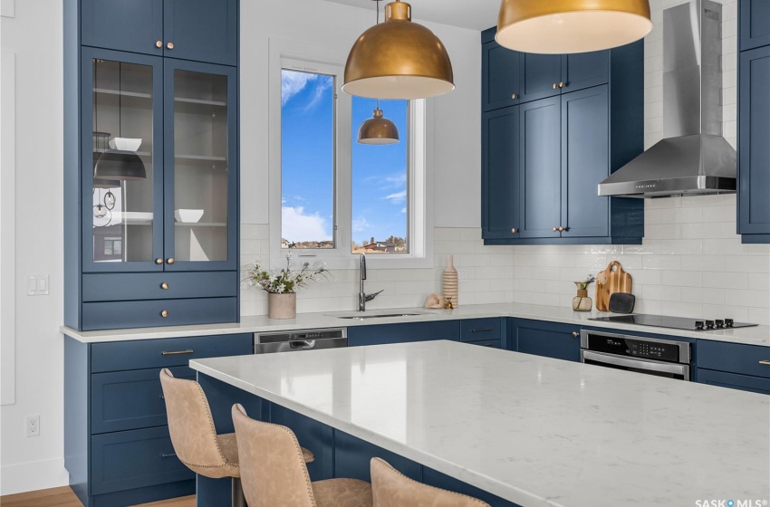 Kitchen featuring a center island, tasteful backsplash, exhaust hood and appliances with stainless steel finishes.