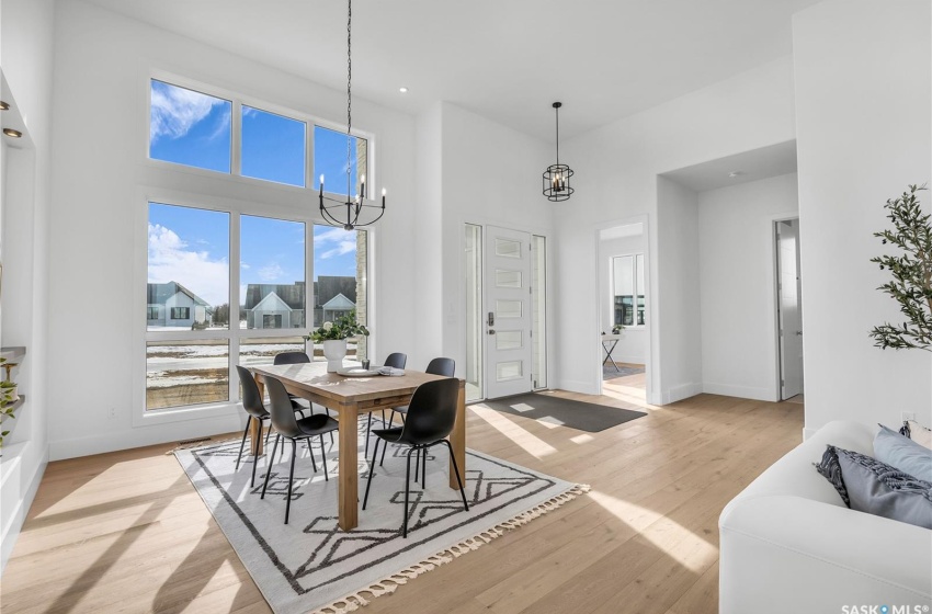 Dining space with a notable chandelier, light flooring and high ceiling.