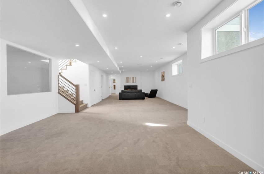 Finished basement with light colored carpet, gym area and 2 bedrooms.