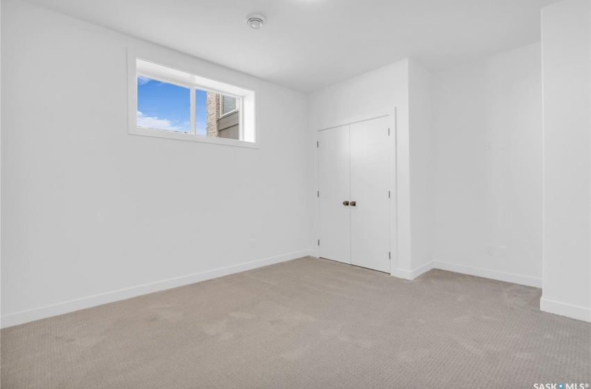 Finished basement with light colored carpet, gym area and 2 bedrooms.