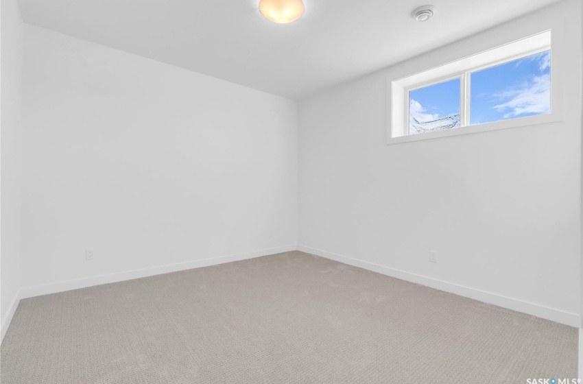 Finished basement with light colored carpet, gym area and 2 bedrooms.