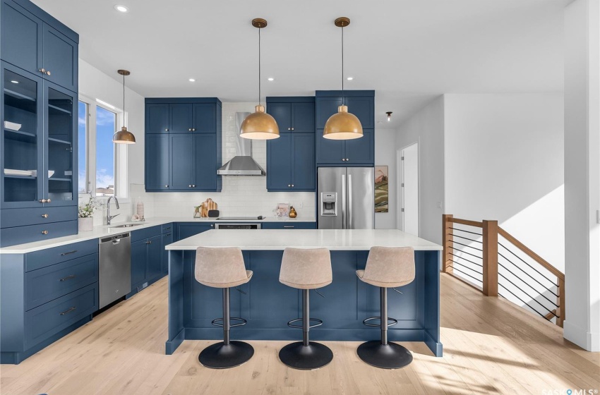 Kitchen featuring a center island, tasteful backsplash, exhaust hood and appliances with stainless steel finishes.