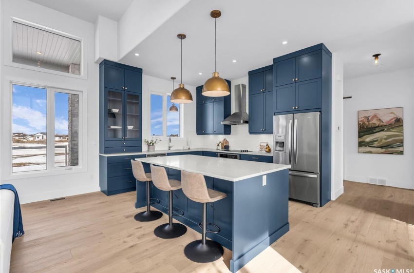 Kitchen featuring a center island, tasteful backsplash, exhaust hood and appliances with stainless steel finishes.