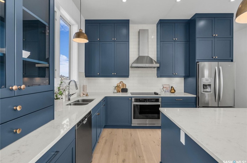 Kitchen featuring a center island, tasteful backsplash, exhaust hood and appliances with stainless steel finishes.