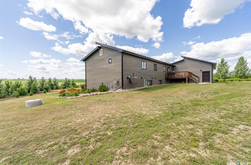 Back of house with a lawn and a deck