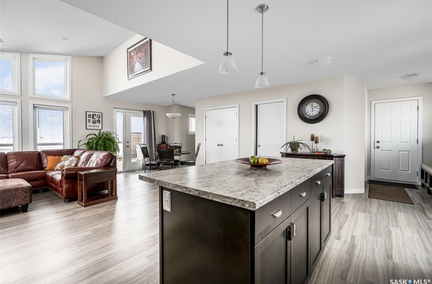 Kitchen featuring dark brown cabinets, hanging light fixtures, light wood-type flooring, and a center island