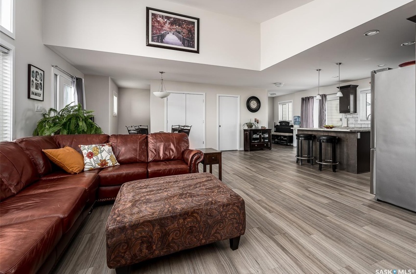 Living room with a high ceiling, a wealth of natural light, and dark wood-type flooring