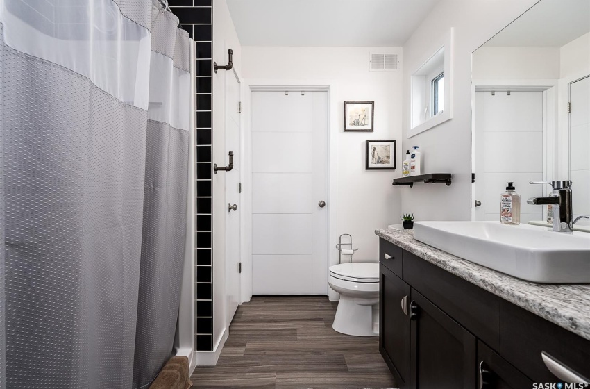 Bathroom with hardwood / wood-style floors, vanity, and toilet