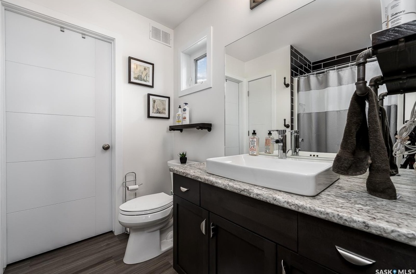 Bathroom with hardwood / wood-style flooring, vanity, and toilet