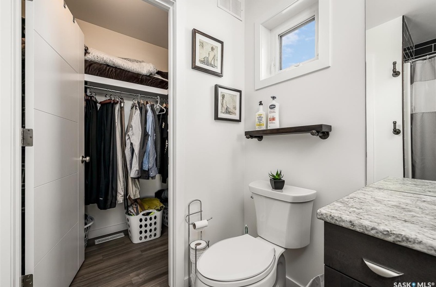 Bathroom featuring hardwood / wood-style flooring, vanity, and toilet