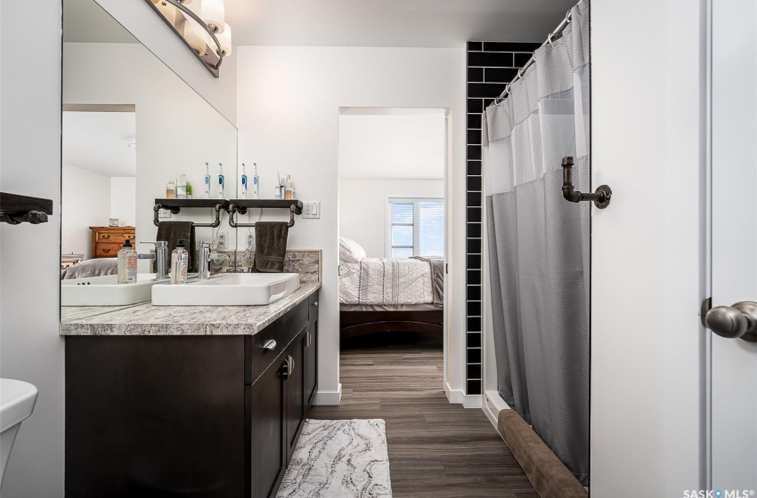 Bathroom featuring hardwood / wood-style floors, vanity with extensive cabinet space, and toilet