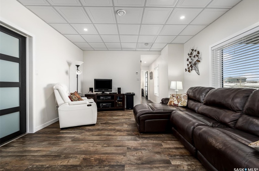 Living room featuring a paneled ceiling and dark hardwood / wood-style flooring