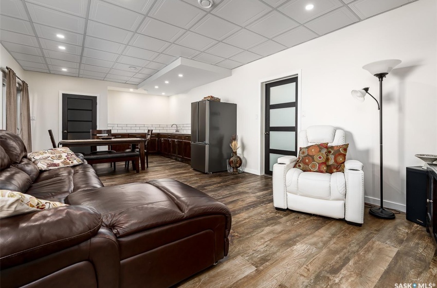 Living room featuring a paneled ceiling and dark hardwood / wood-style floors