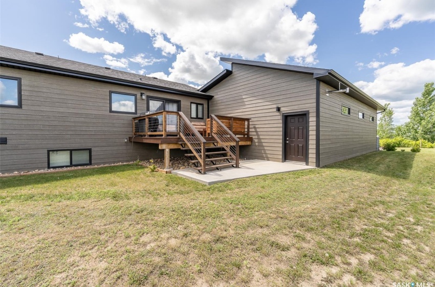 Back of house featuring a patio area, a yard, and a wooden deck