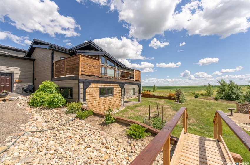 View of side of property featuring a balcony, a rural view, and a yard