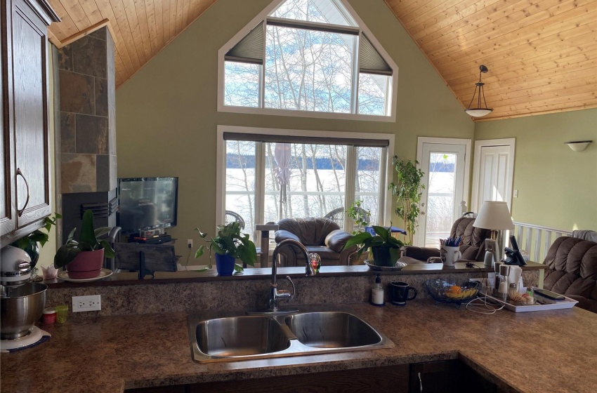 Kitchen featuring high vaulted ceiling, dark brown cabinetry, sink, and wood ceiling