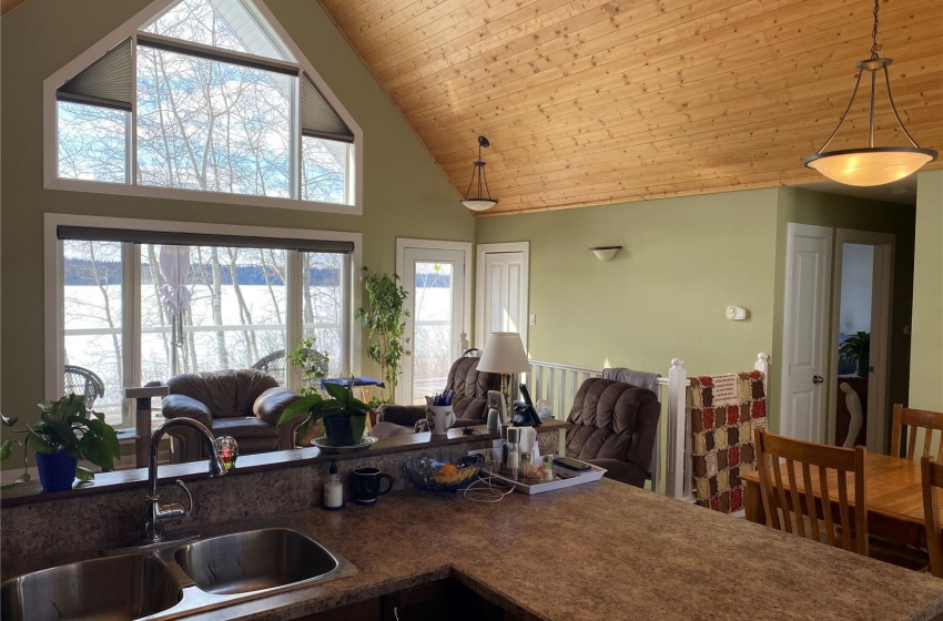 Kitchen with wood ceiling, sink, high vaulted ceiling, and decorative light fixtures