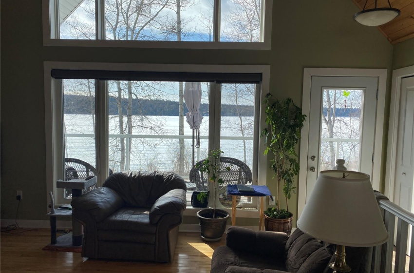 Living room featuring a water view, dark wood-type flooring, and high vaulted ceiling