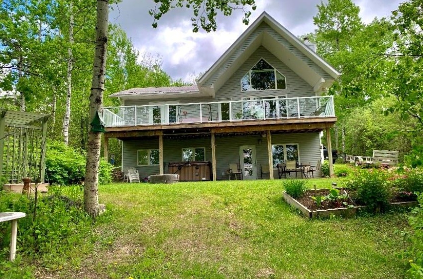 Rear view of property featuring a yard and a hot tub