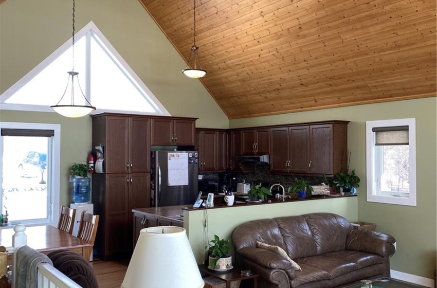 Living room featuring wood ceiling, light hardwood / wood-style flooring, high vaulted ceiling, and ceiling fan