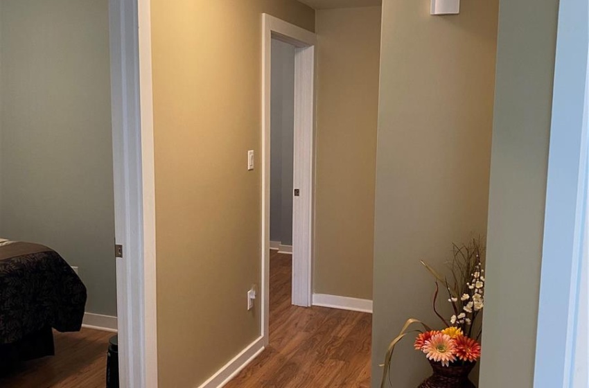 Hallway with hardwood / wood-style flooring and a textured ceiling