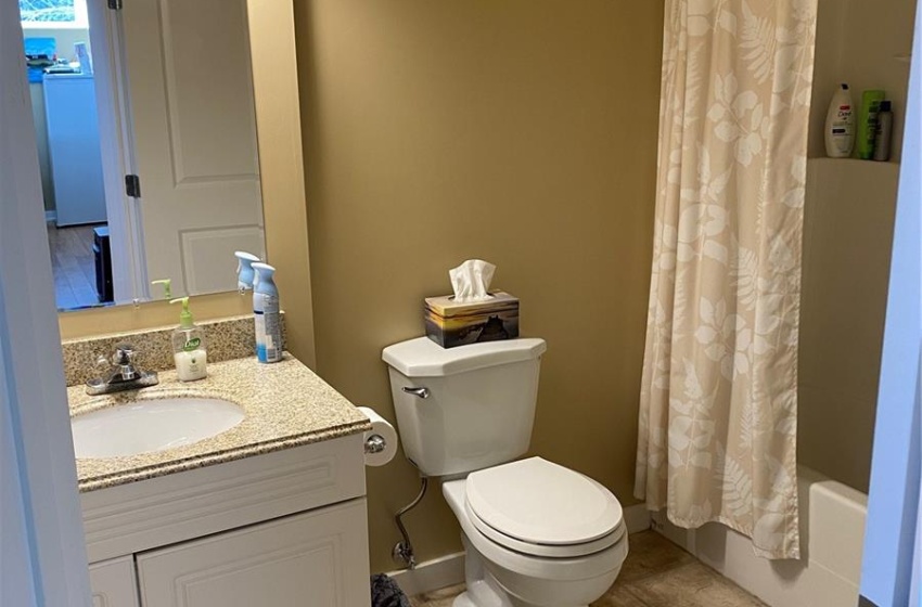 Full bathroom featuring tile floors, vanity, shower / bath combo with shower curtain, and toilet