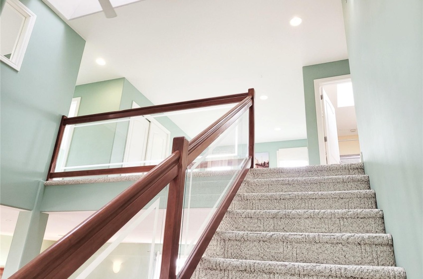 Staircase featuring ceiling fan and a skylight