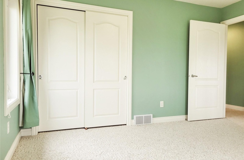 Bedroom with a closet and light colored carpet