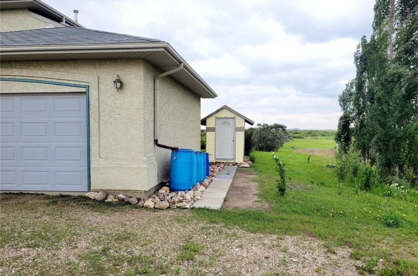 View of home's exterior featuring a lawn, an outdoor structure, and a garage